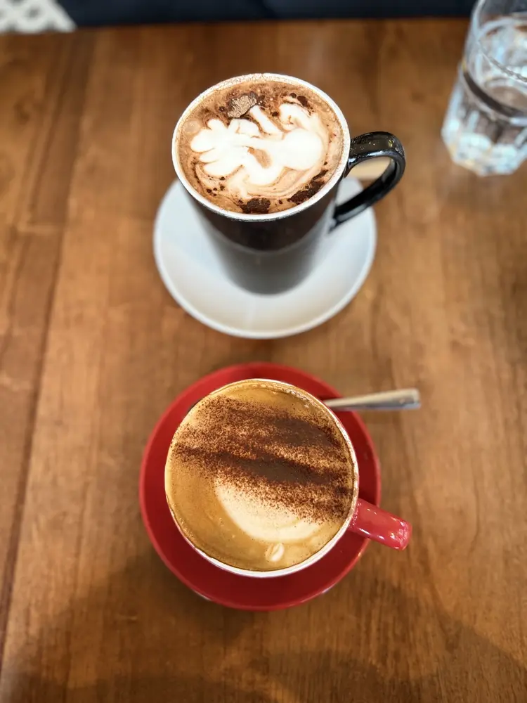 Mocha and cappuccino with cocoa dusting on a wooden table